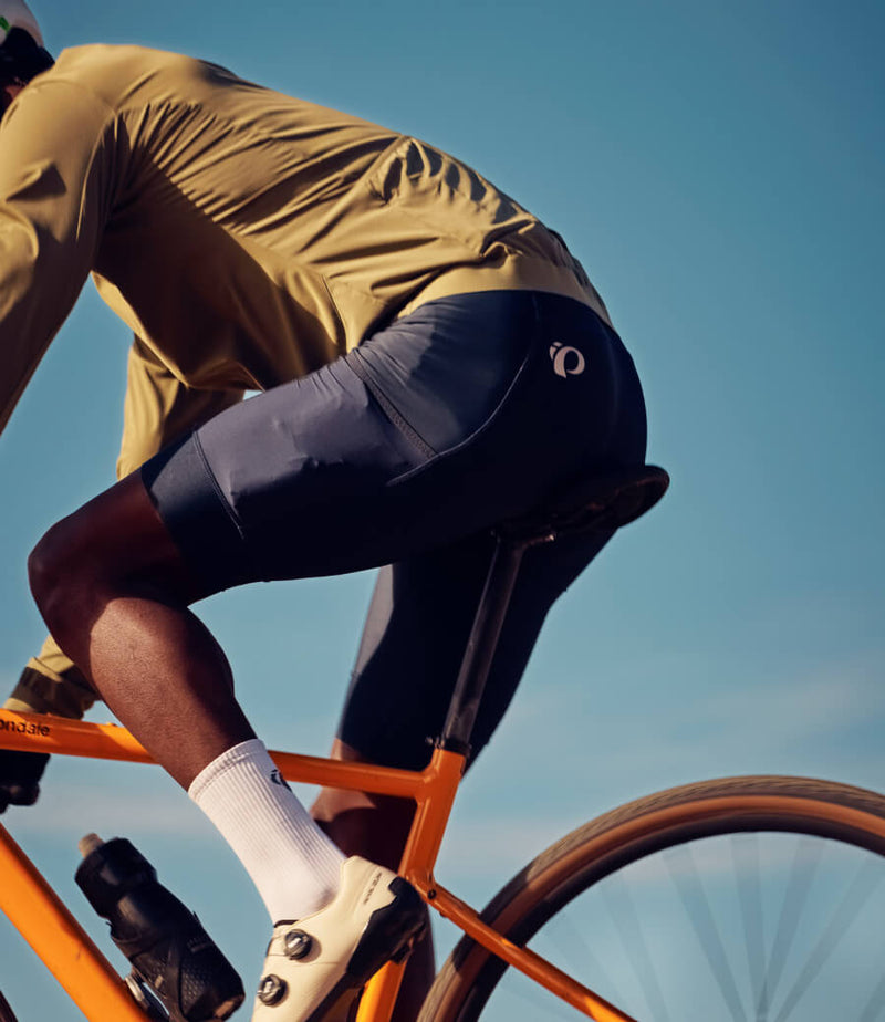 Cyclist straddling bike with olive cycling bib shorts featuring the cargo pocket