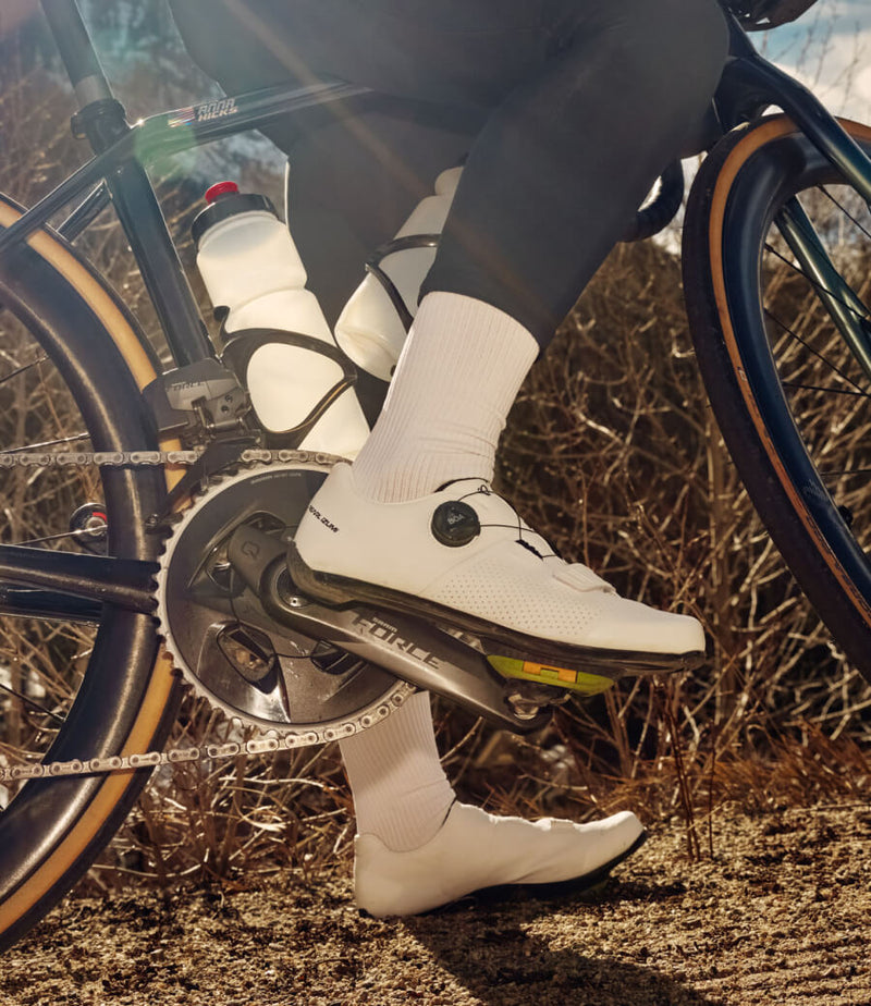 Closeup shot of cyclist on bike with cycling socks and white cycling shoes