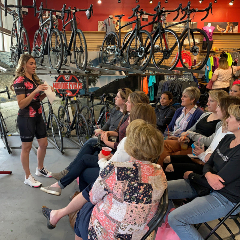 Female Cyclist Speaking to a Bike Shop Full of Women