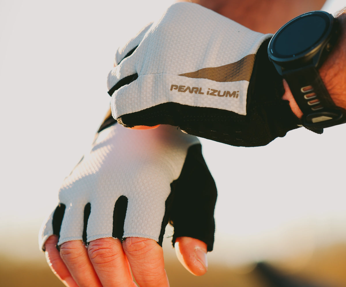 Close-up of a hand wearing a PEARL iZUMi cycling glove with a blurred background