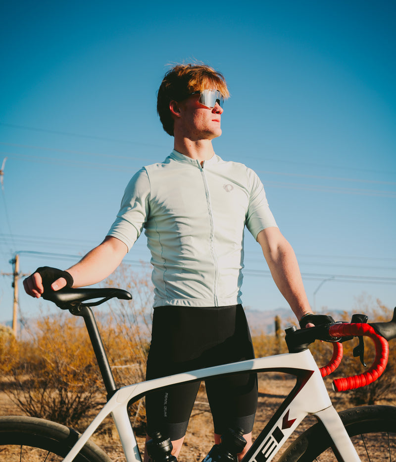 Man standing with a road bike in PEARL iZUMi kit