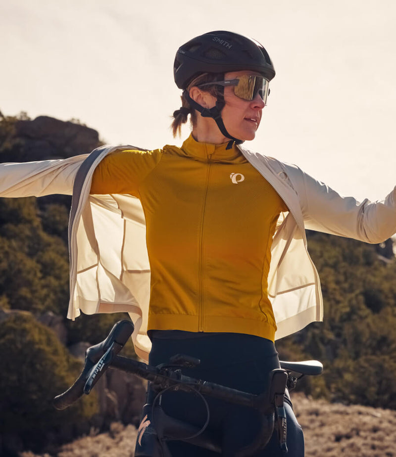 Female cyclist standing over bike wearing a cycling vest