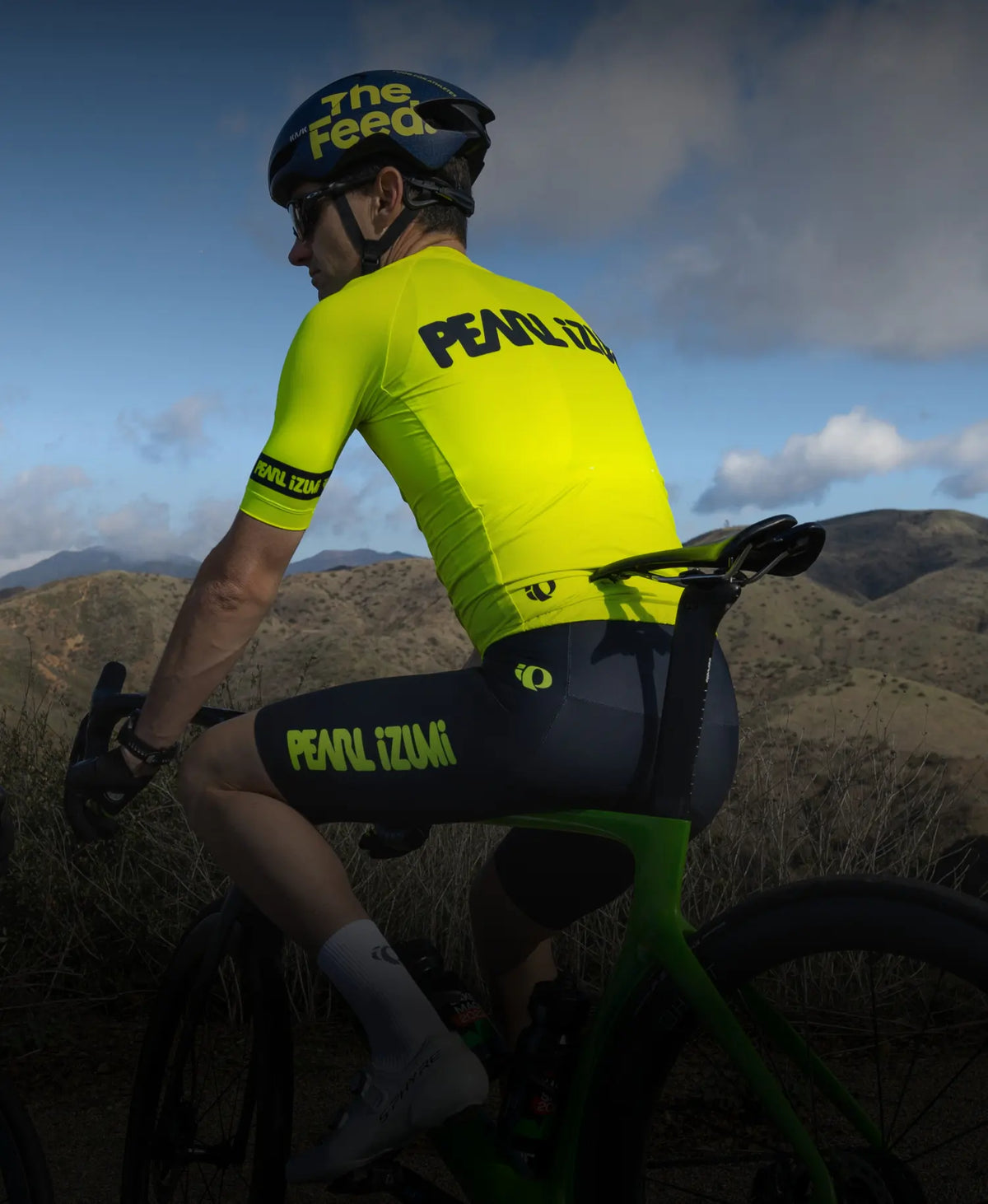 Cyclist standing over his bike wearing PEARL iZUMi screaming yellow BioViz gear