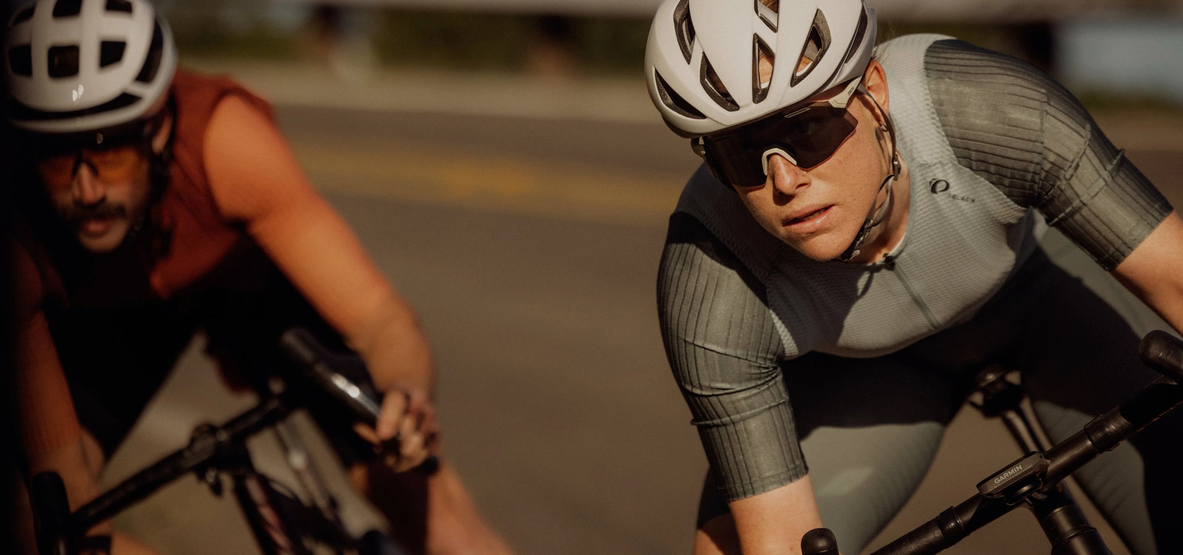 Two cyclists in racing gear on a road