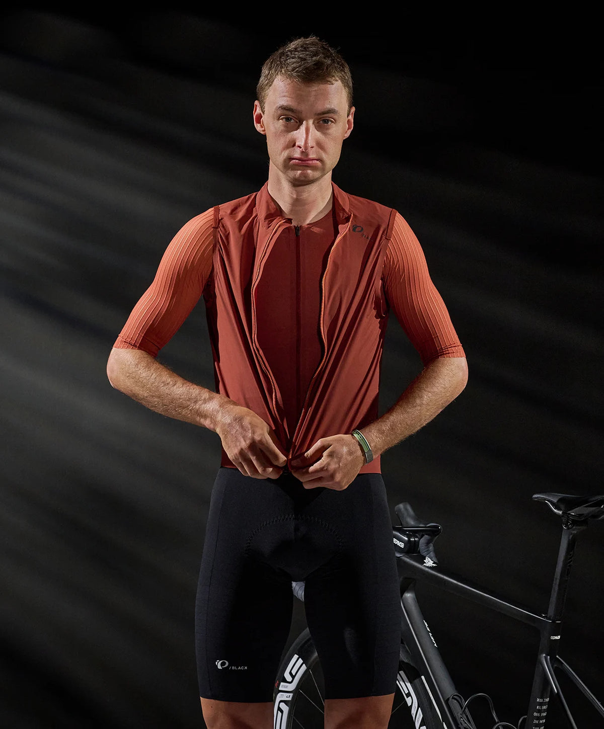 Man wearing a red cycling outfit with a black background